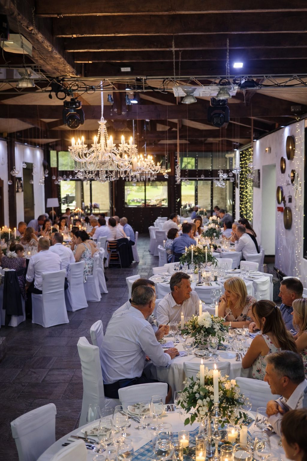 Dîner de mariage dans une salle de réception élégante près d’Arras dans le Pas-de-Calais avec lustres en cristal et grandes tables rondes décorées